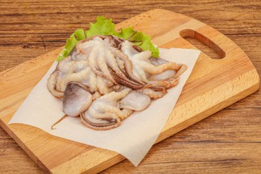 Çiğ deniz ürünleri - ahtapot tahtada pişirmek için.