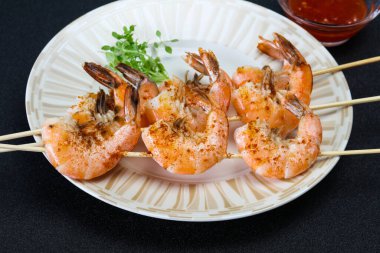 Baharatlı soslu ızgara karides şişi.