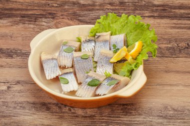 Dilimlenmiş limonla marine edilmiş ringa filetosu.