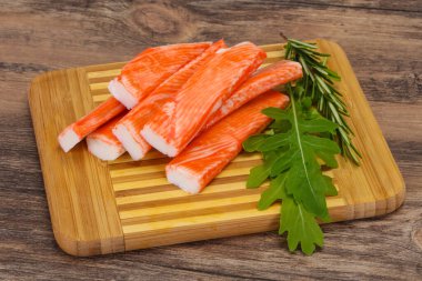 Ahşap tahtanın üzerinde yengeç çubuğu surimi