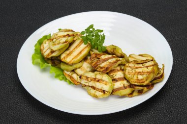 Izgara patlıcan dilimleri fesleğen ve salata yaprakları servis edilir.