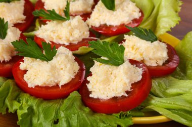 Peynirli domates dilimleri maydanoz ve salata yaprakları.