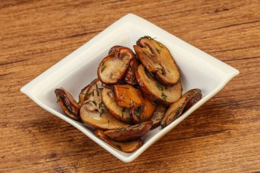 Kavrulmuş şampiyon, kasede otlar ve baharatlar var.