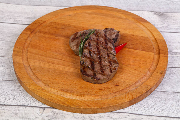 Grilled Fillet Mignon with rosemary and chili pepper over the wooden background