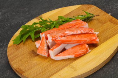 Ahşap tahtanın üzerinde yengeç çubuğu surimi