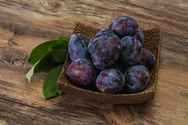 Olgun erik yığını sepetin içinde yapraklarla