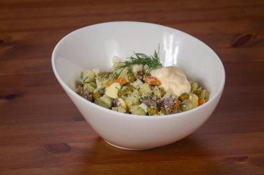 Etli ve bezelyeli geleneksel Rus salatası.