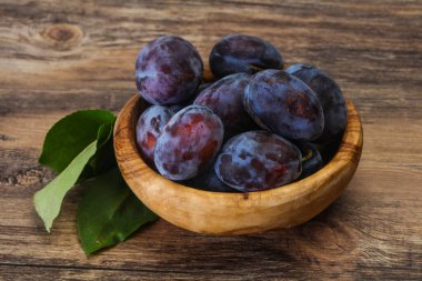 Olgun erik yığını sepetin içinde yapraklarla