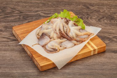 Çiğ deniz ürünleri - ahtapot tahtada pişirmek için.