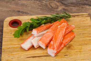 Ahşap tahtanın üzerinde yengeç çubuğu surimi