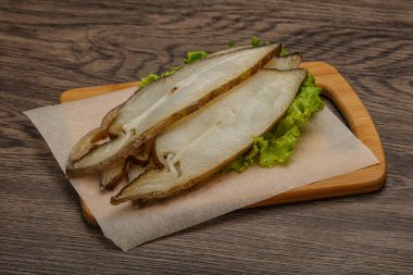 Lezzetli füme halibut balığı aperatifi keser.