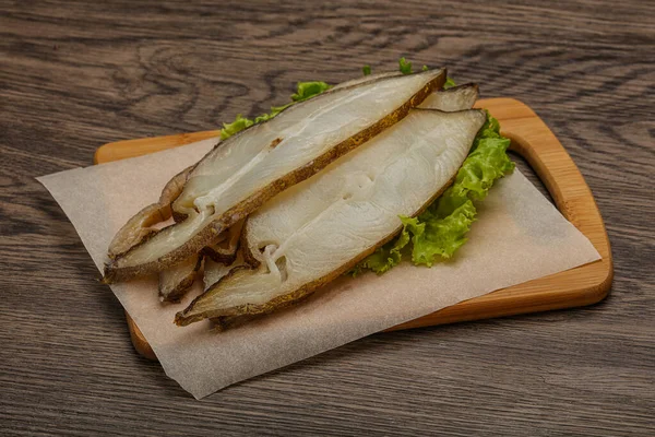 Lezzetli füme halibut balığı aperatifi keser.