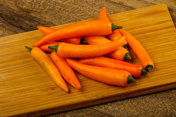 Sıcak sarı biber yığın ahşap arka plan üzerinde