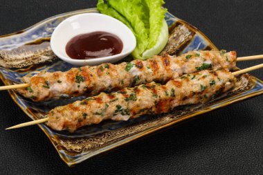İnce kıymalı domuz şişi kebap ve bbq sosu.