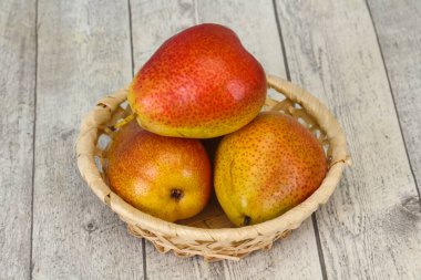 Tahta sepetteki olgun armut yığını.