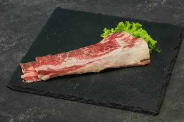 Tahtanın üzerinde çiğ domuz pastırması salata ve kekik servis edildi.