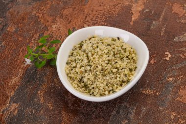 Ahşap arka planda kabuktaki kenevir tohumları.