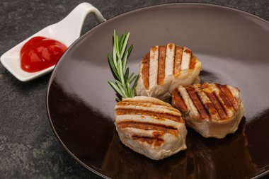 Domates soslu ızgara domuz madalyonu. Biberiye servis ediliyor.