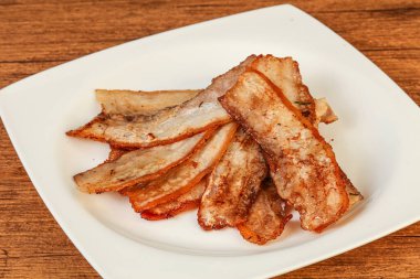 Kızarmış domuz pastırması tabakta.