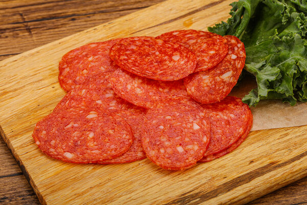 Italian spycy pepperoni sausage slices over board
