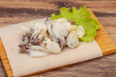 Çiğ deniz ürünleri, güvertede pişirmek için mürekkep balığı.