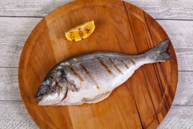 Tahtanın üzerinde limonlu ızgara dorada.