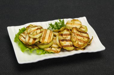 Izgara patlıcan dilimleri fesleğen ve salata yaprakları servis edilir.