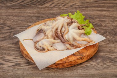 Çiğ deniz ürünleri - ahtapot tahtada pişirmek için.