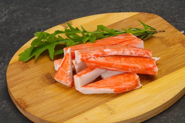 Ahşap tahtanın üzerinde yengeç çubuğu surimi