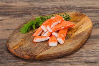 Ahşap tahtanın üzerinde yengeç çubuğu surimi