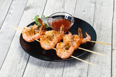 Baharatlı soslu ızgara karides şişi.