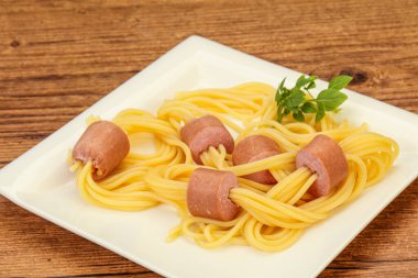 Çocuklar sosisli ve fesleğenli makarna.