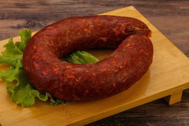 Tahtanın üzerinde Krakowska sosisi otlar ve baharatlarla