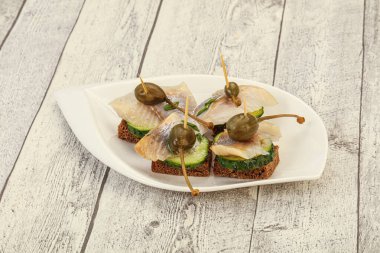 Ringa fileto kanepe aperatifi, yabanmersini ve salatalık.