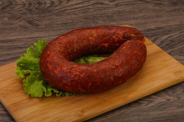 Tahtanın üzerinde Krakowska sosisi otlar ve baharatlarla