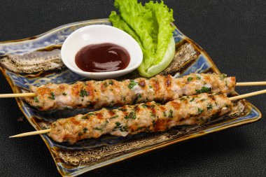İnce kıymalı domuz şişi kebap ve bbq sosu.