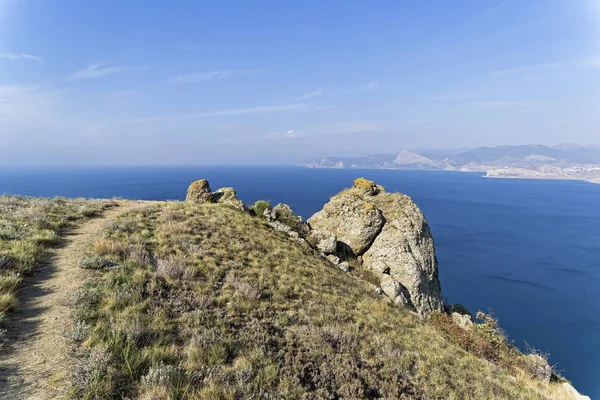 Footpath on a steep coastal mountain. Cape Meganom, Crimea, sunny day in September.