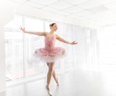 Elegante Balletttänzerin in rosa Tutu übt und lächelt