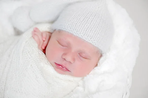 Neugeborenes Baby in weißer Tragetasche liegt auf Korb — Stockfoto