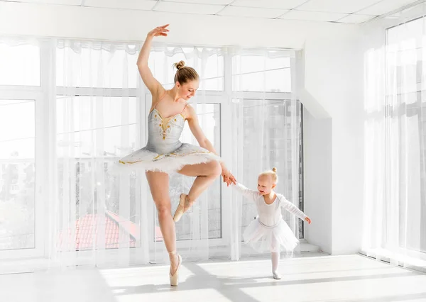 Unga vackra ballerina med hennes lilla dotter dansar i studio — Stockfoto