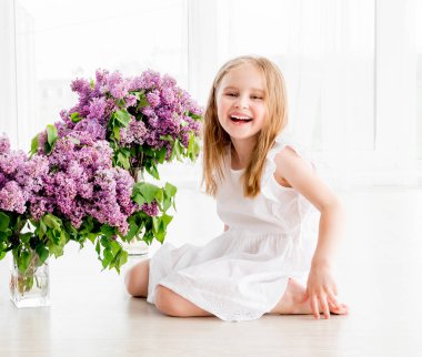 Eflatun çiçekli Beyaz elbiseli neşeli küçük kız