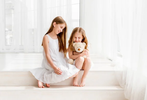 Μικρό κορίτσι δίνει το αρκουδάκι παιχνίδι σε παλαιότερη αδελφή — Φωτογραφία Αρχείου