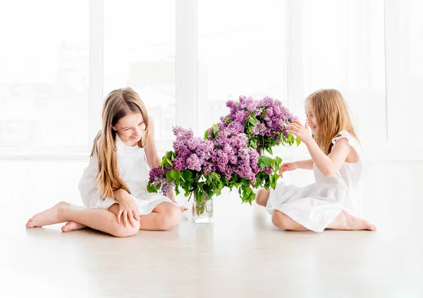 Niñas sonrientes con ramo de lila —  Fotos de Stock