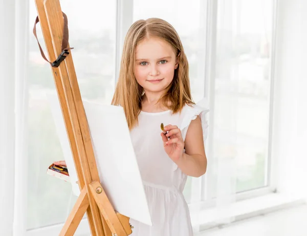 Porträt eines kleinen Mädchens, das ein Bild auf Staffelei zeichnet — Stockfoto