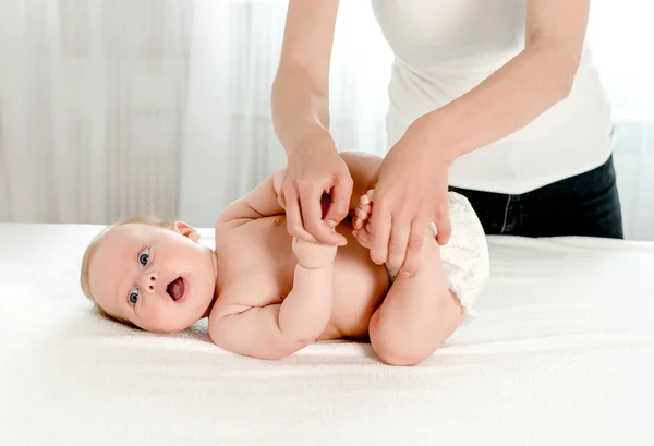 Mother massaging her infant baby — Stock Photo, Image