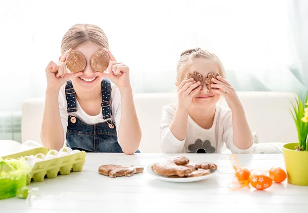 Meninas felizes segurando biscoitos de Páscoa na frente de seus olhos — Fotografia de Stock