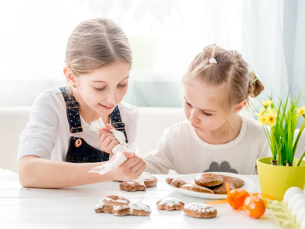 Дитяча дівчинка прикрашає пасхальне печиво — стокове фото