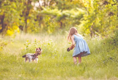 Little girl running with the dog in the countryside clipart