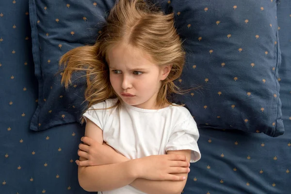 Kind meisje liggend op het bed weigert te slapen — Stockfoto