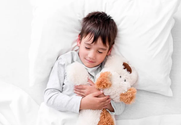 Chłopiec dziecko trzymając pluszowe zabawki podczas snu — Zdjęcie stockowe